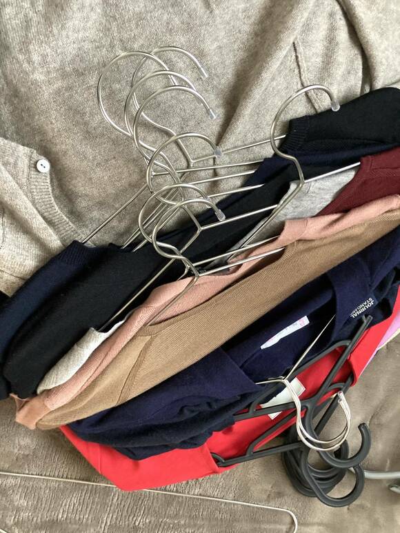 ハンガーにかけられた衣類積み重ね