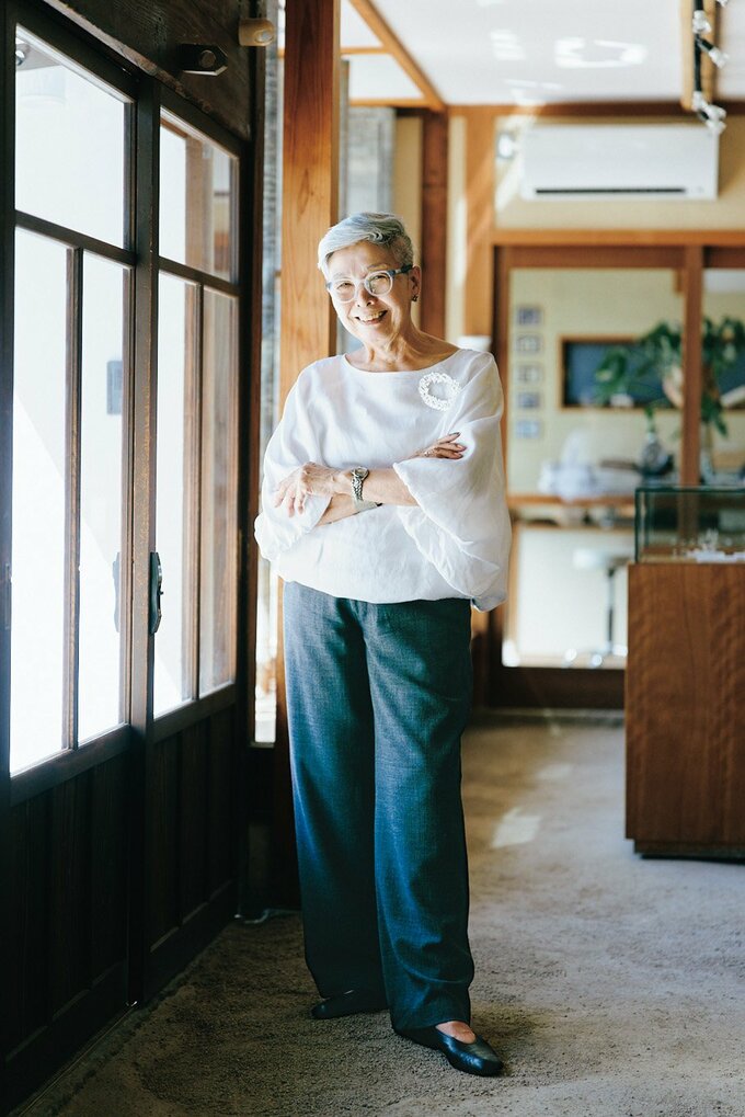 透かし彫りの端材でつくった楕円形のブローチ。左の鎖骨の下に着けると、安定感があって引き締まる。ブラウス（ミズイロインド）、パンツ（プランテーション）、靴（カンペール）