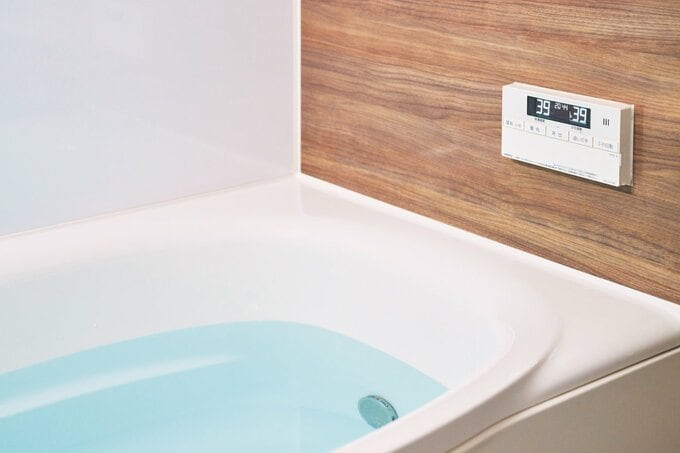 お湯がはられた浴槽と木目調の浴室
