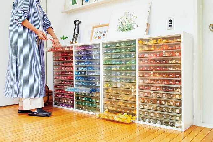 アトリエの壁に並べられた刺しゅう糸ケース