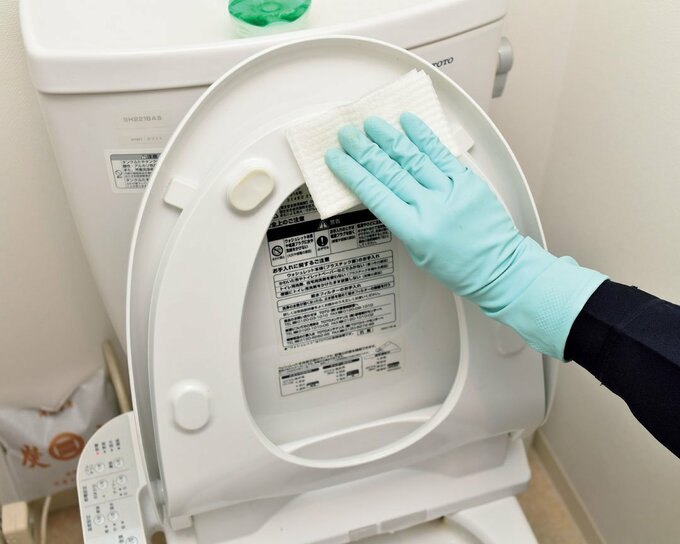 トイレ掃除用シートで便座をふく様子