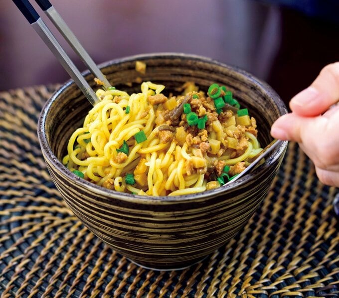 箸とスプーンで麺類を混ぜる様子