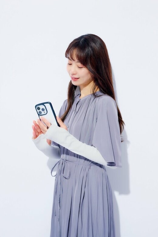 アームウォーマーを着用してスマホを操作する女性