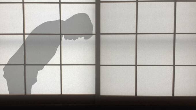 礼をしている人の影