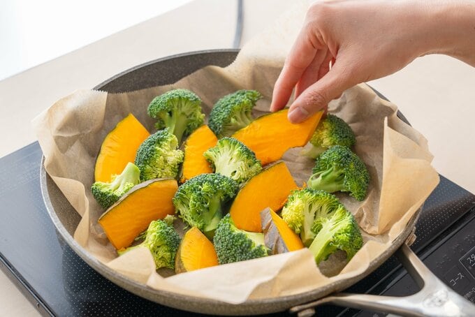 クッキングシートに乗ったかぼちゃとブロッコリー