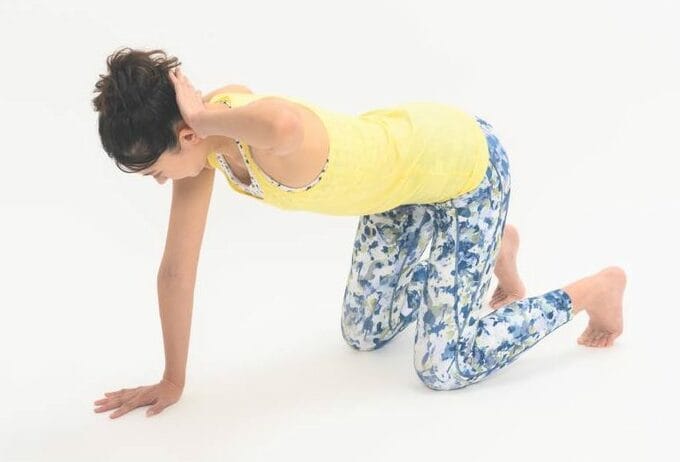 手を後頭部に当てる