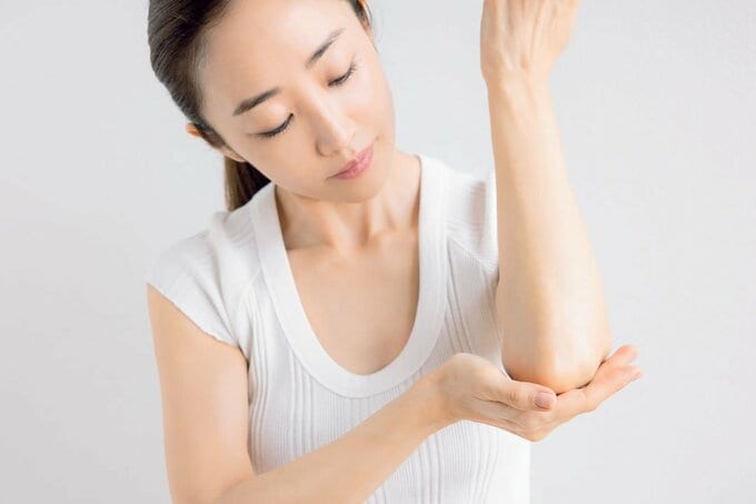 ひじを触る女性