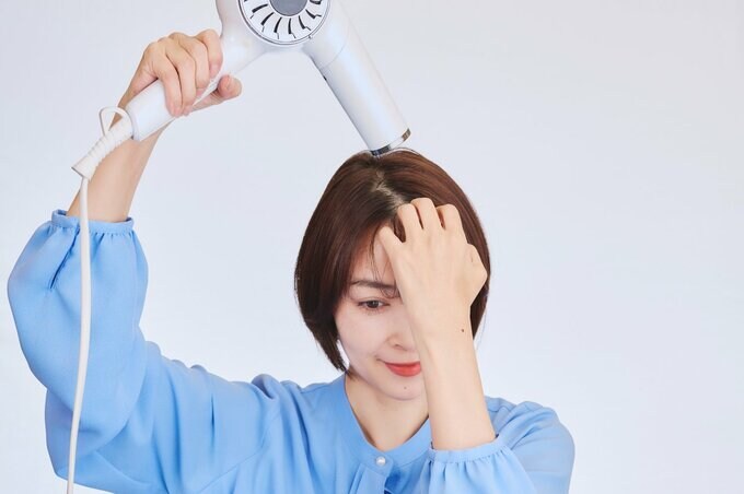 前髪を乾かす女性
