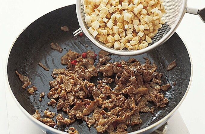 炒めた牛肉にゴボウを加える
