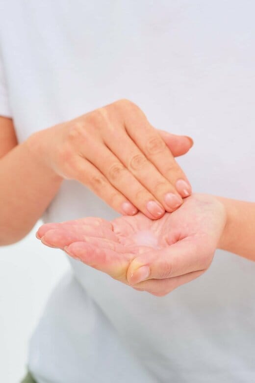 化粧水を手のひらに出している人