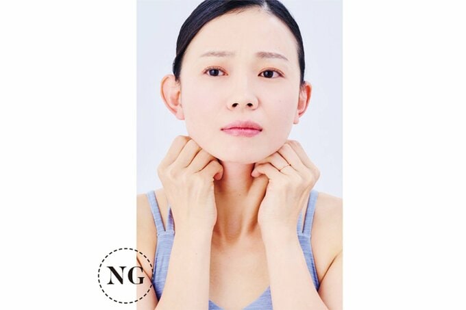 左右の胸鎖乳突筋をつかむ女性 