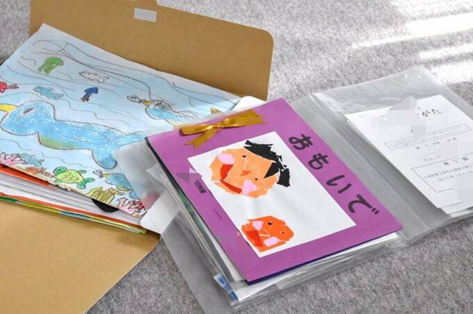 画用紙に書いた絵や通知表、成長の記録をファイルやクリアファイルに収納した様子