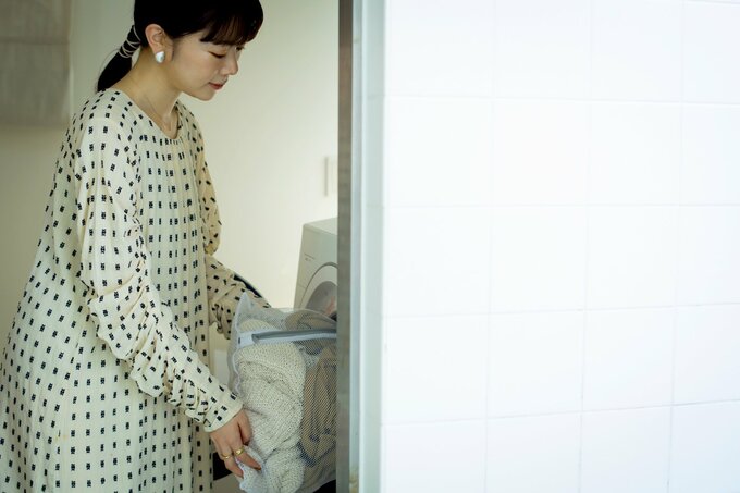 洗濯物を洗濯機に入れるNIKOさん