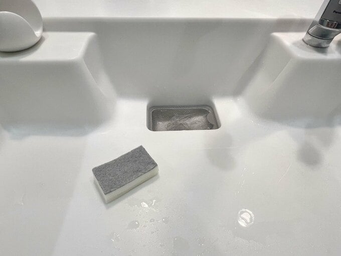 スポンジで排水口を洗う