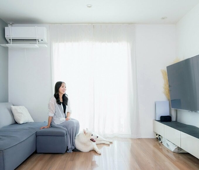 ソファーに座る女性と足元に白い犬