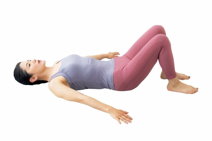 仰向けになってひざを立てている女性