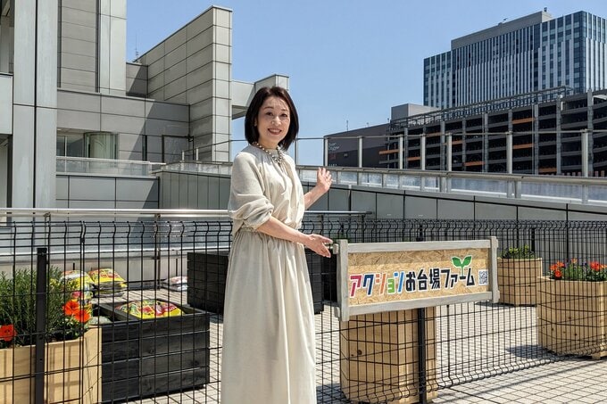 菜園の前に立つ女性