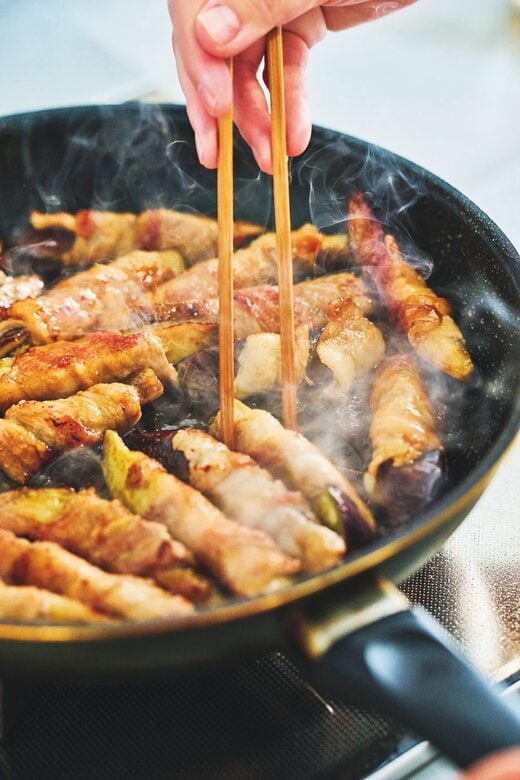 フライパンでナスの肉巻きを炒めている様子