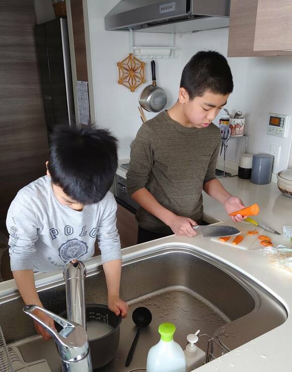 米をとぐ子どもと人参を切る子ども