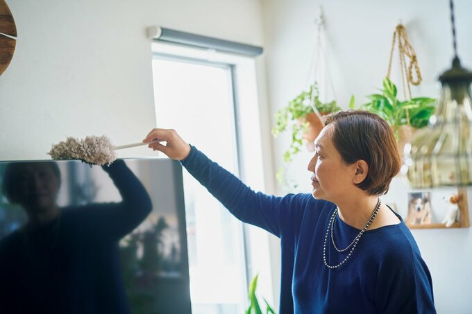 テレビの上をハンディモップでふく五味さん
