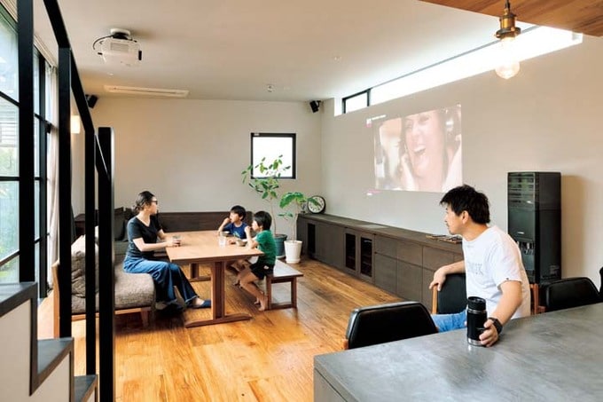 プロジェクターで写した映像を見る家族