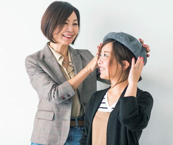 女性二人、ベレーを触っている所