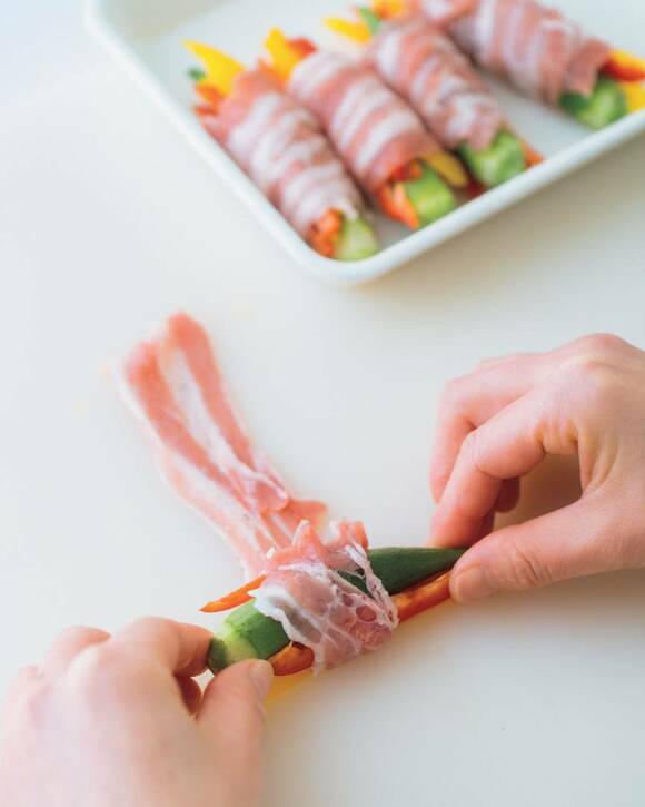 肉で野菜を巻く様子