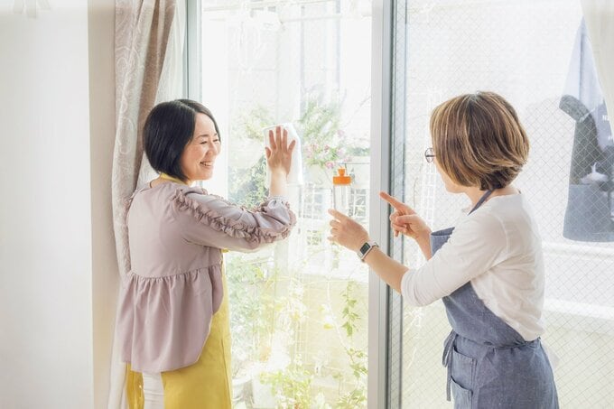 窓ふきをする女性と食器用洗剤を持つ女性