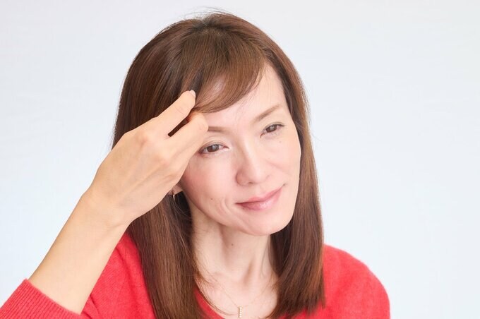 前髪を流す女性