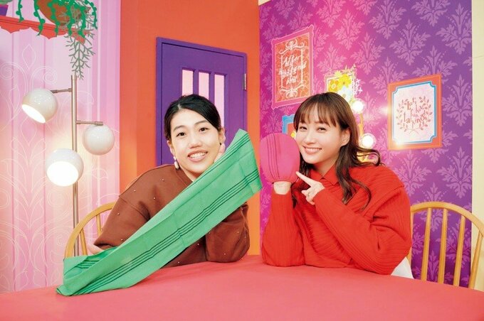 韓国式あかすりタオルを持つ横澤夏子さんと韓国式あかすりミトンをはめる藤本美貴さん