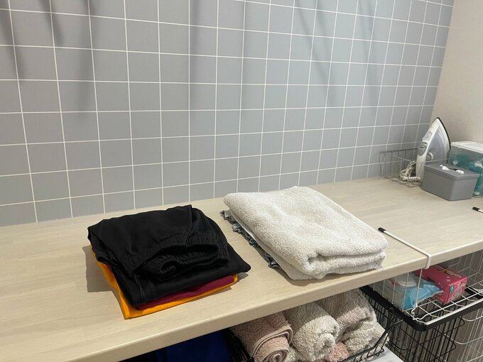 ランドリールームのカウンターで洗濯物をたためる