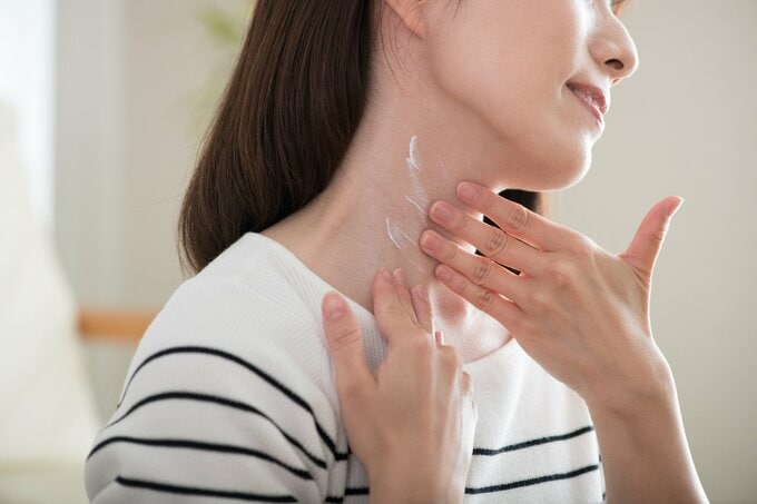 首に日焼け止めを塗る女性