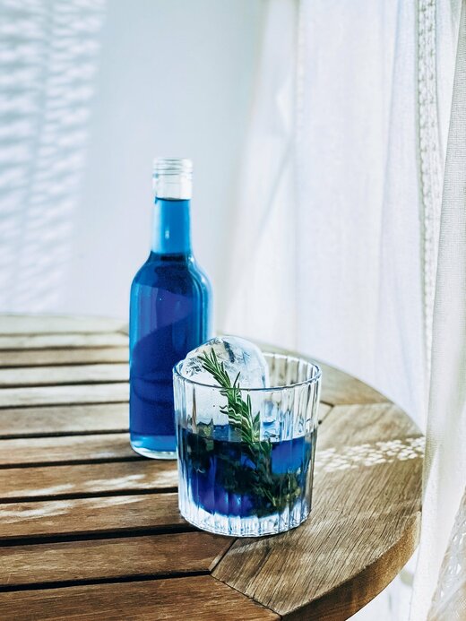 テーブルに置かれた青い水が入った瓶とコップ