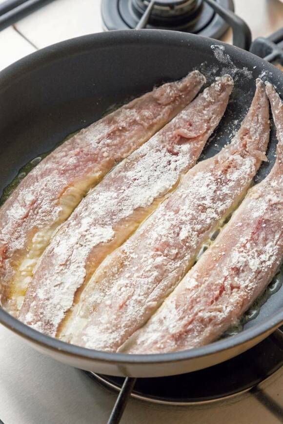 サンマに小麦粉をまぶして焼く様子