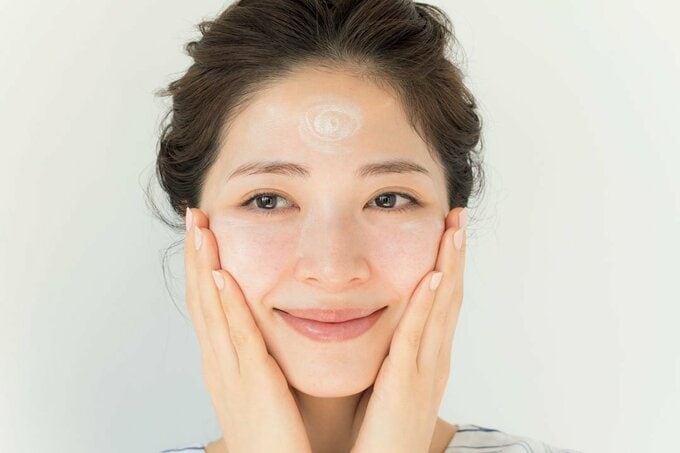 手のひらを内から外に滑らせて、肌に薄膜をはるように化粧下地を伸ばす様子