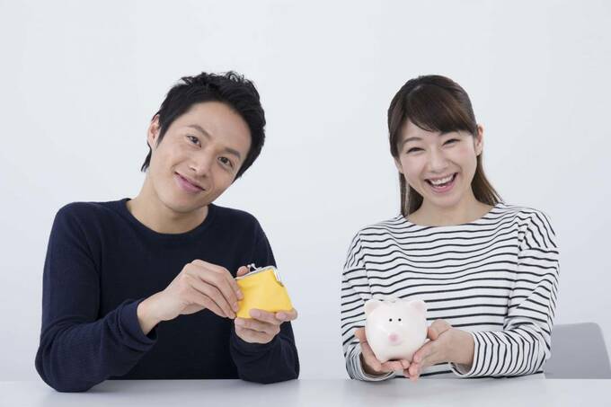 財布を持つ男性と貯金箱を持つ女性