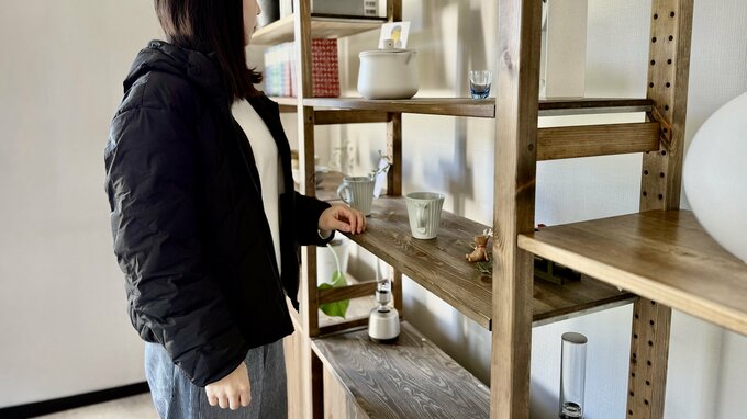 室内で防寒着を着る女性