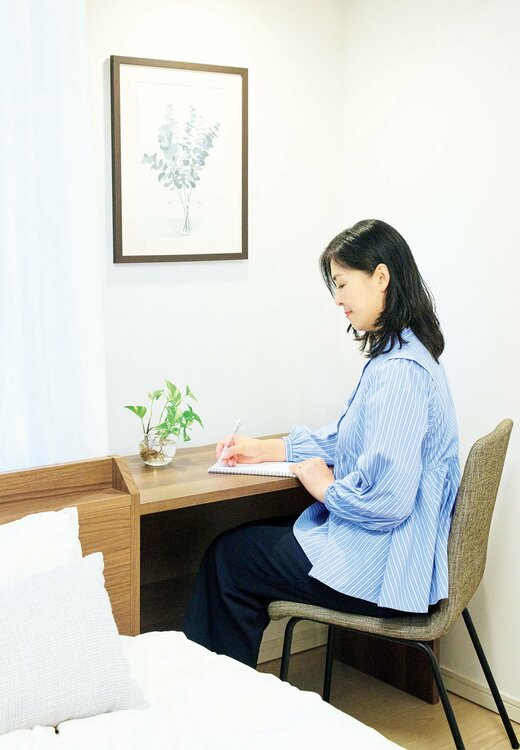 ベッド横にデスクで作業するむらさきさん