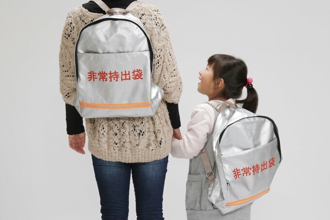 防災バッグを持つ家族