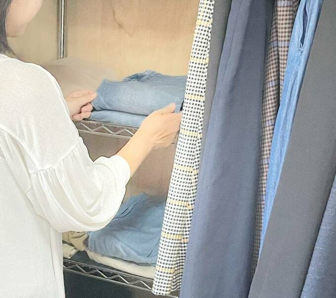 クローゼットの服を整える女性