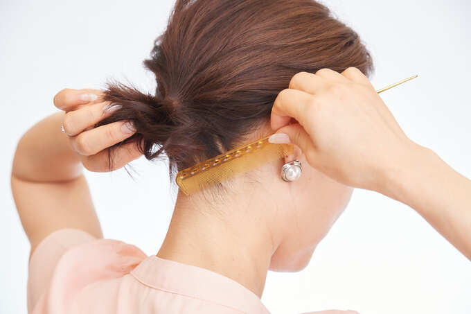 えり足の毛をおさえている女性