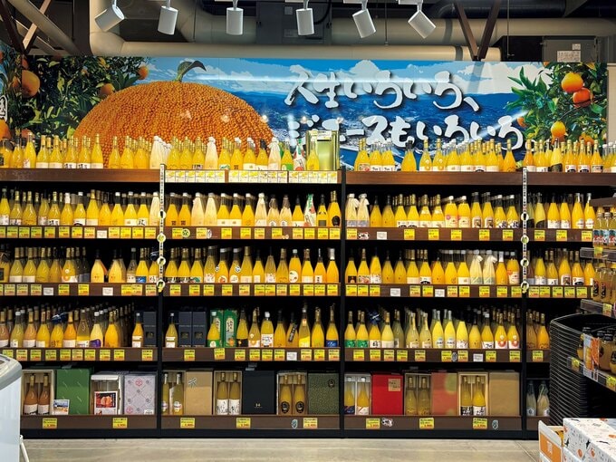 棚に陳列された数多くのかんきつ系ジュースの瓶