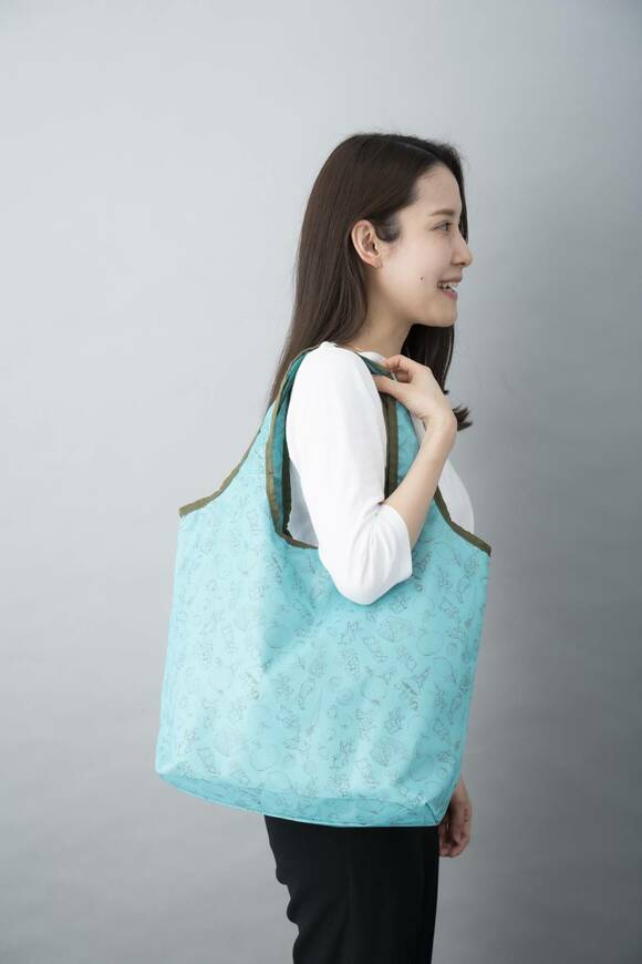 ピーターラビットのショッピングバッグをかける女性