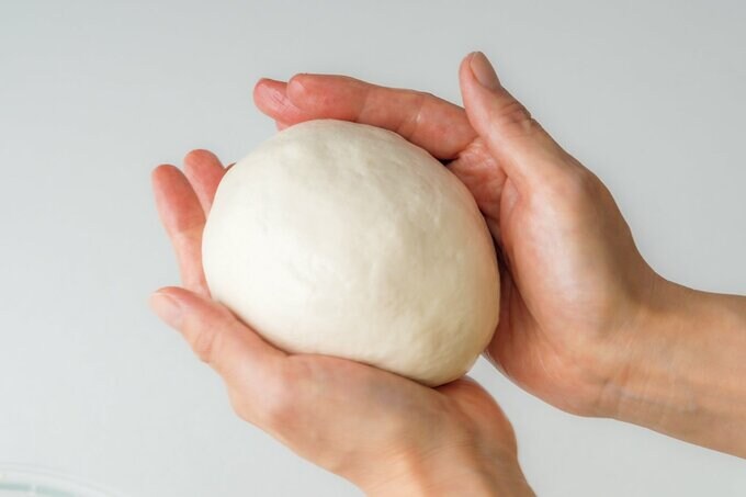 パン生地の空気を抜いて表面を滑らかにする様子