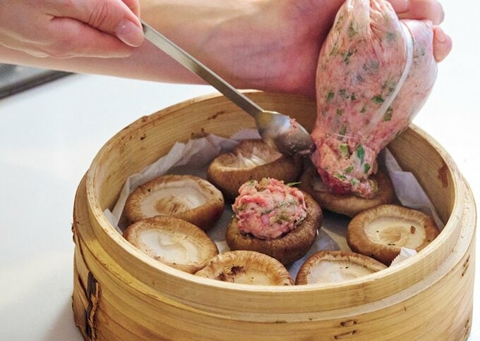 混ぜ合わせた具材を袋から絞り出してシイタケにのせている