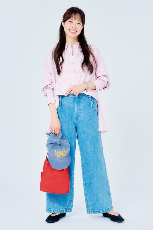 笑顔で立つピンクシャツを着た女性