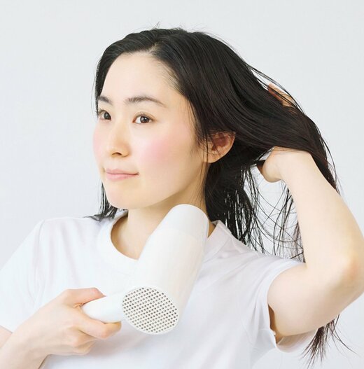 髪を持ち上げ下からドライヤーを当てる女性
