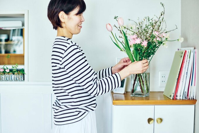リビングに花を飾る人