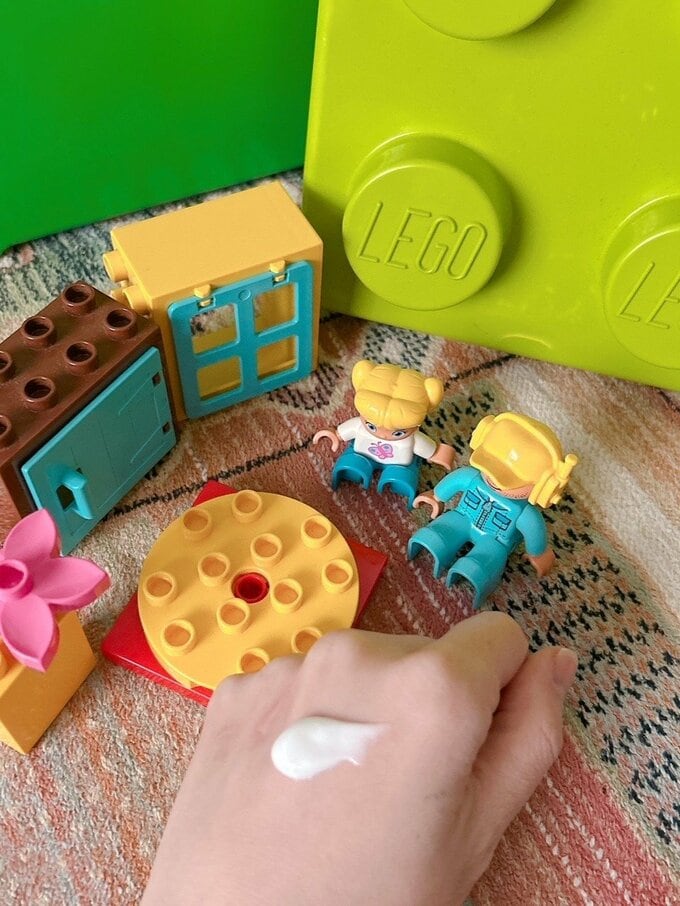 オモチャとハンドクリームをのせた手