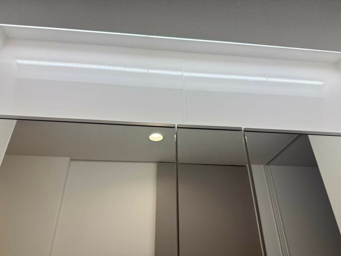 鏡の背面のキッチンパネルに掘り込み照明がくっきり反射